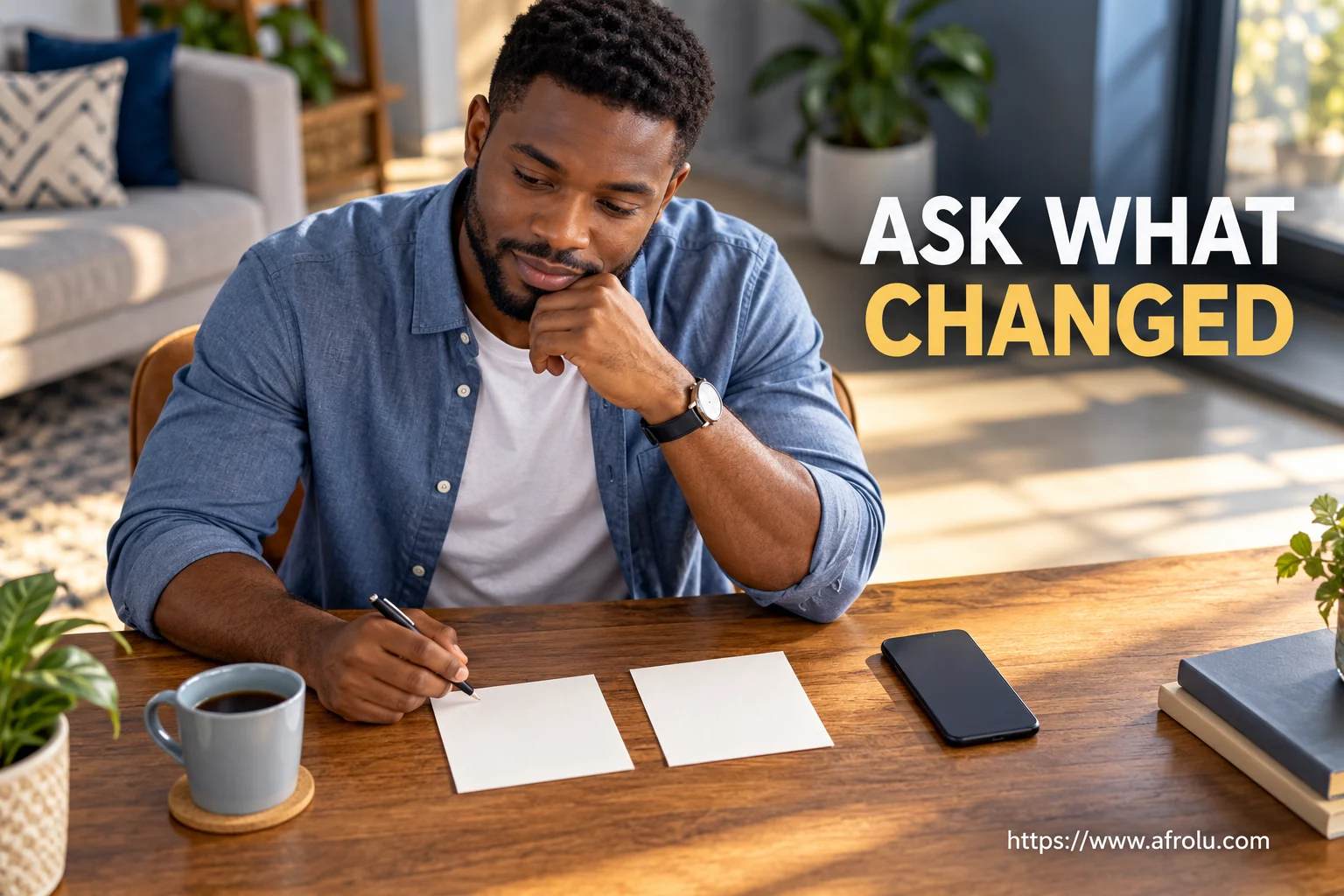 An adult sits at a table with an unbranded phone and two blank notes.
