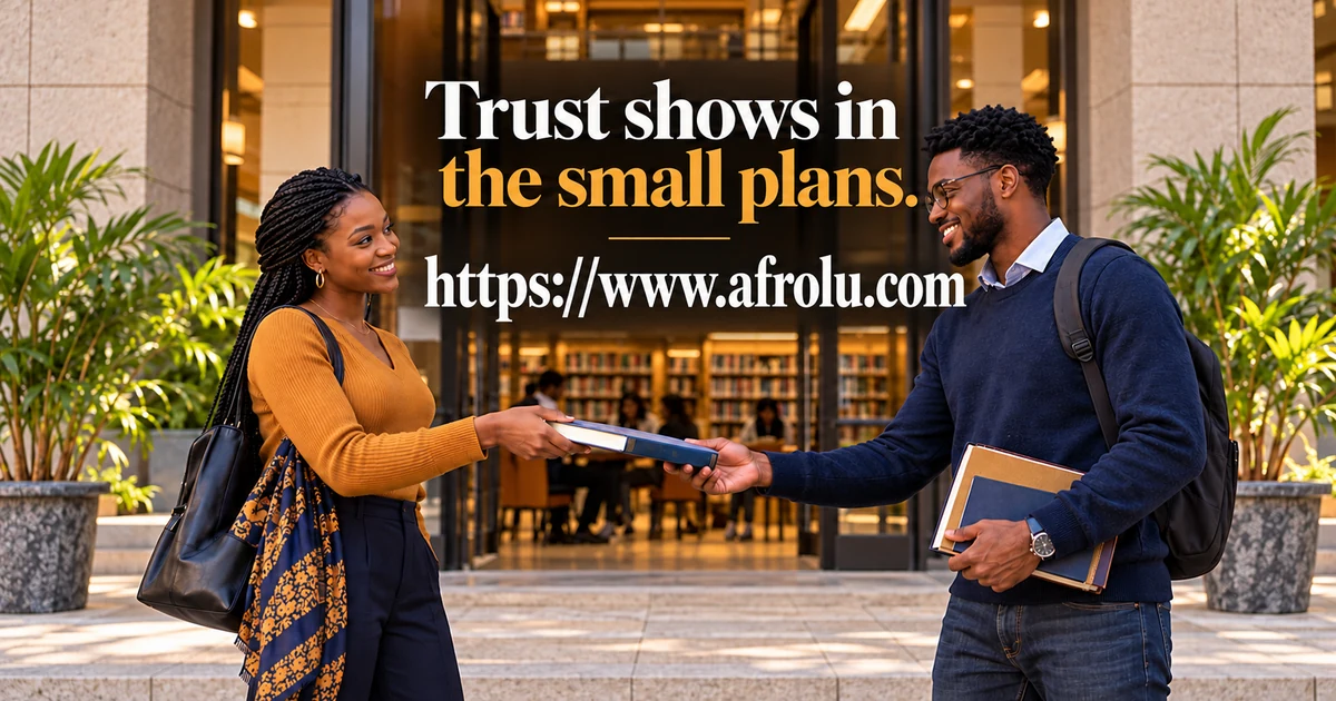 Two adult Black students smile while returning a borrowed book at a public library entrance.