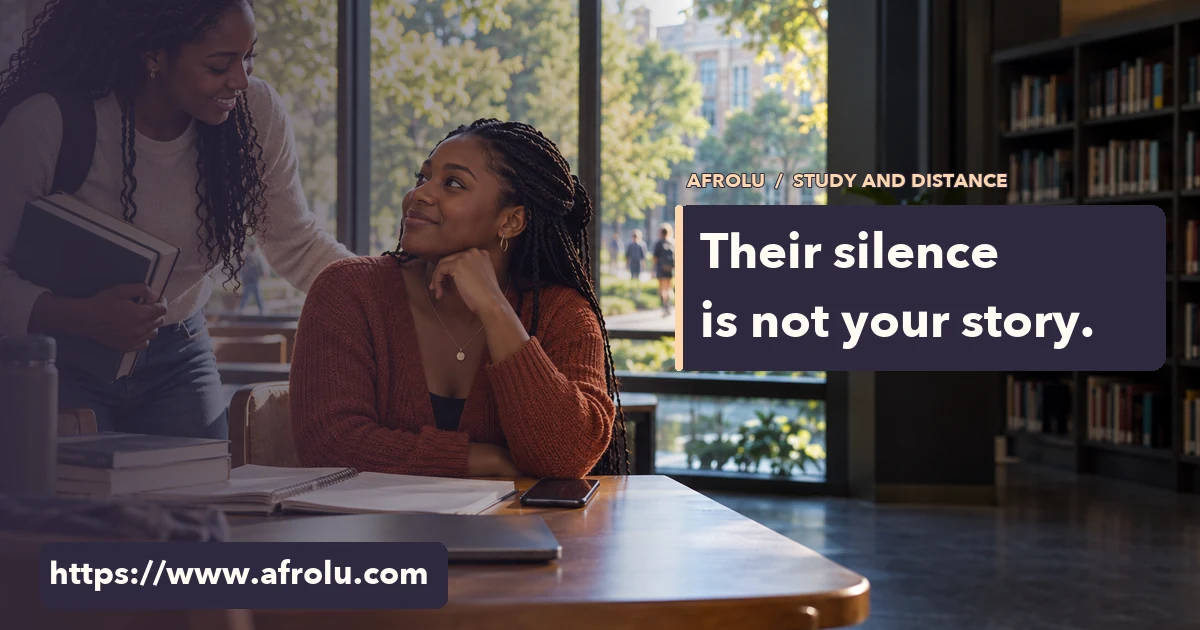 An adult student talks with a friend at a campus library table after setting down her phone.