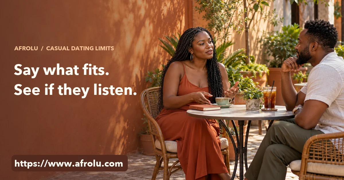 Two adults talk across a courtyard cafe table; one speaks with an open hand while the other listens.