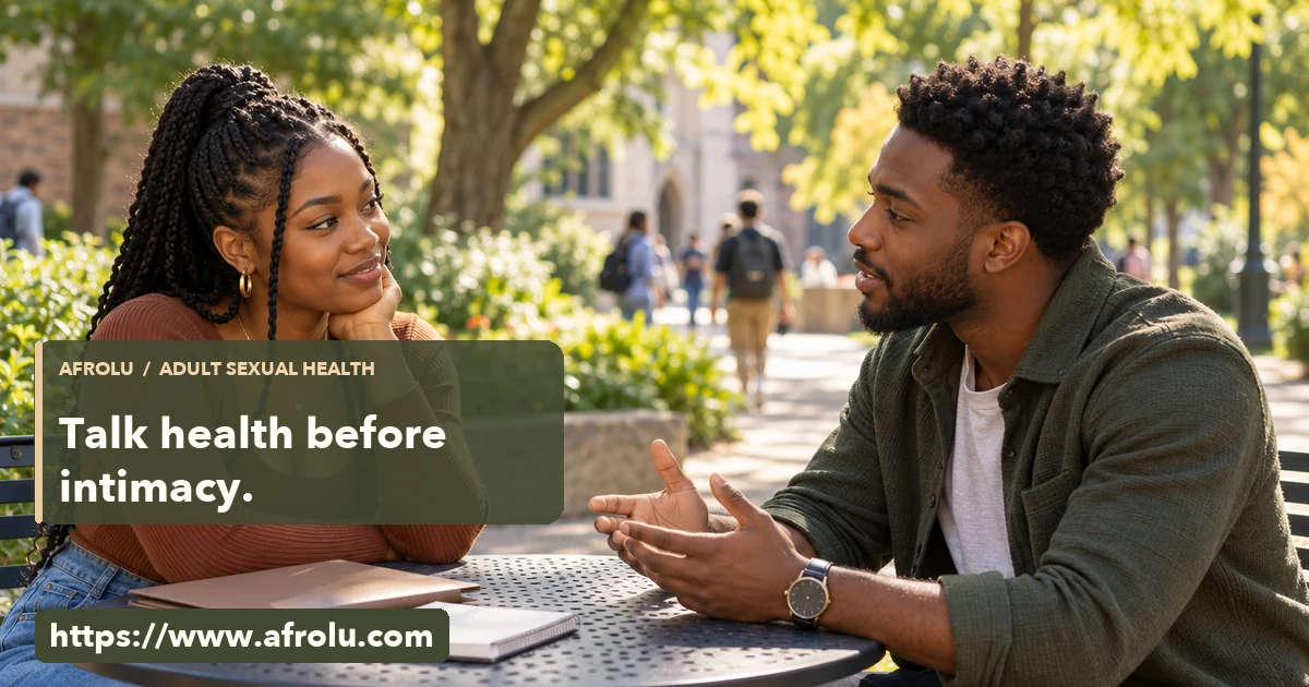 Two adult Black university students talk calmly across an outdoor campus table with a blank notebook.