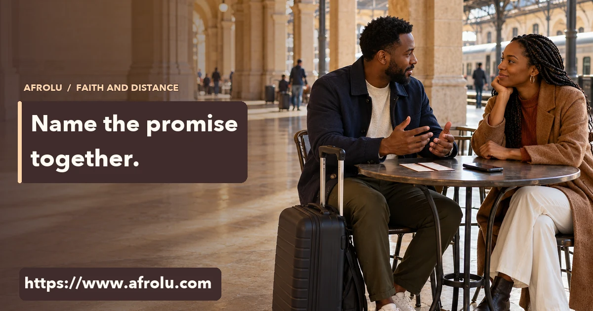 Two adults talk beside a travel bag at a railway station table.