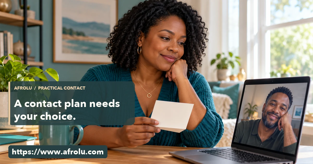 An adult reads a paper contact card while speaking with a long-distance partner on a laptop.