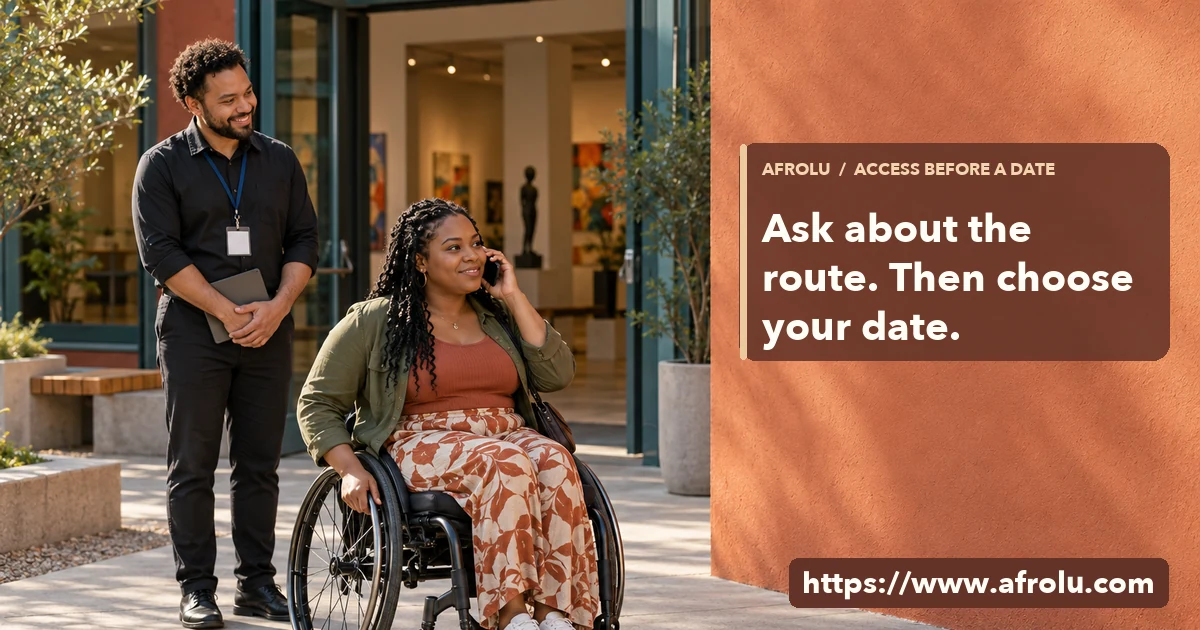 Adult wheelchair user makes a phone enquiry outside a public arts venue as a staff member stands nearby.