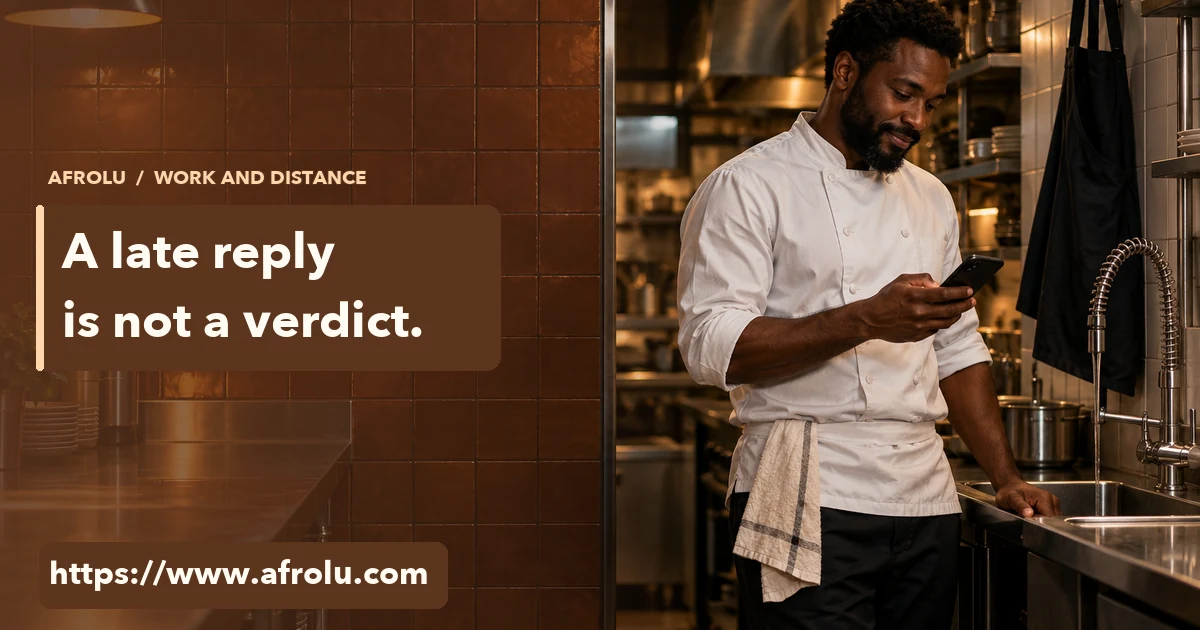 A restaurant chef checks his phone after service beside a clean kitchen counter.