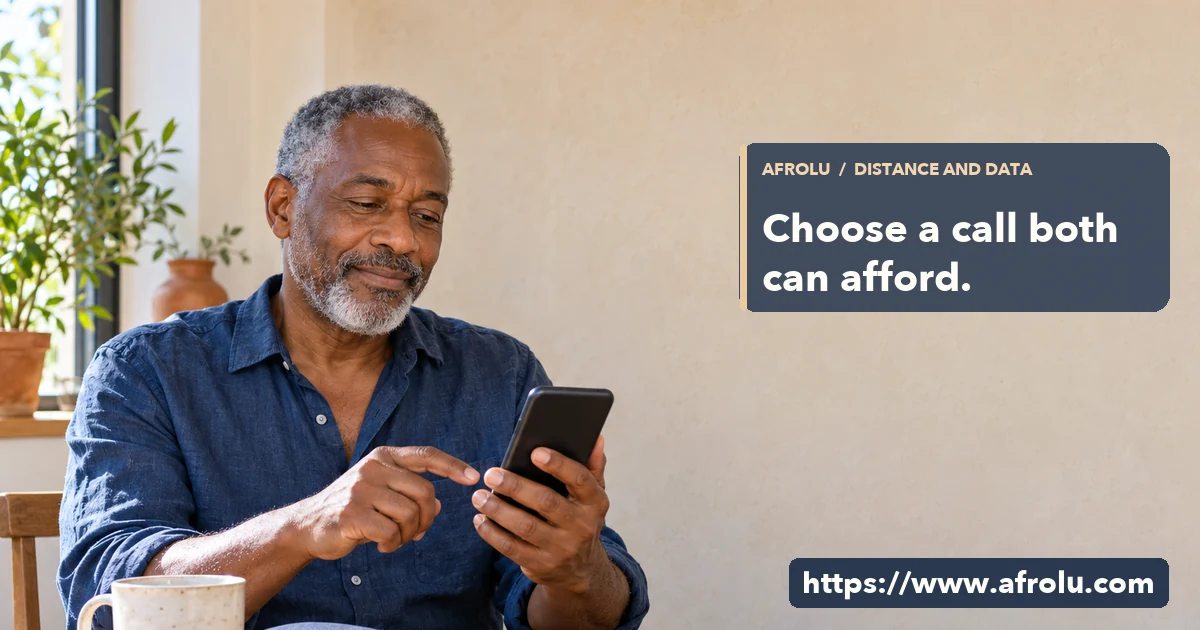 Older adult looks at a phone at a sunlit home table while considering a call.