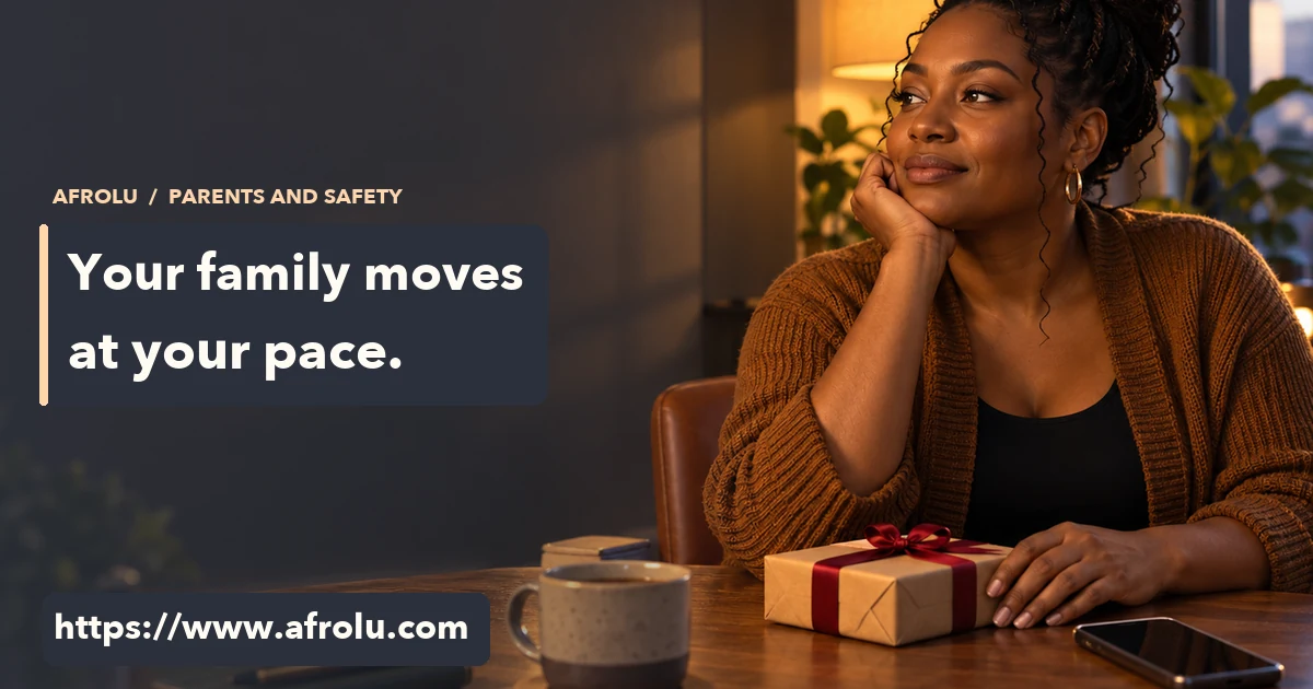 An adult parent considers an unopened small gift beside a blank phone at home.