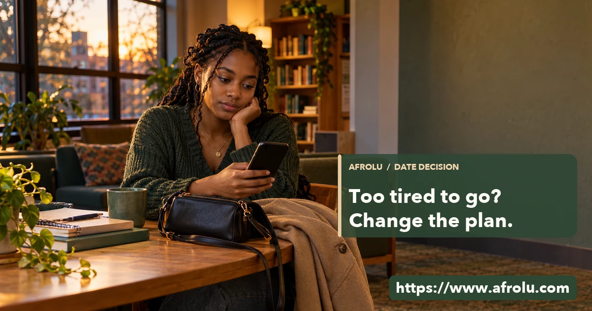 Adult Black graduate student sits in a campus common room with her coat and bag set down as she checks a phone before a date.