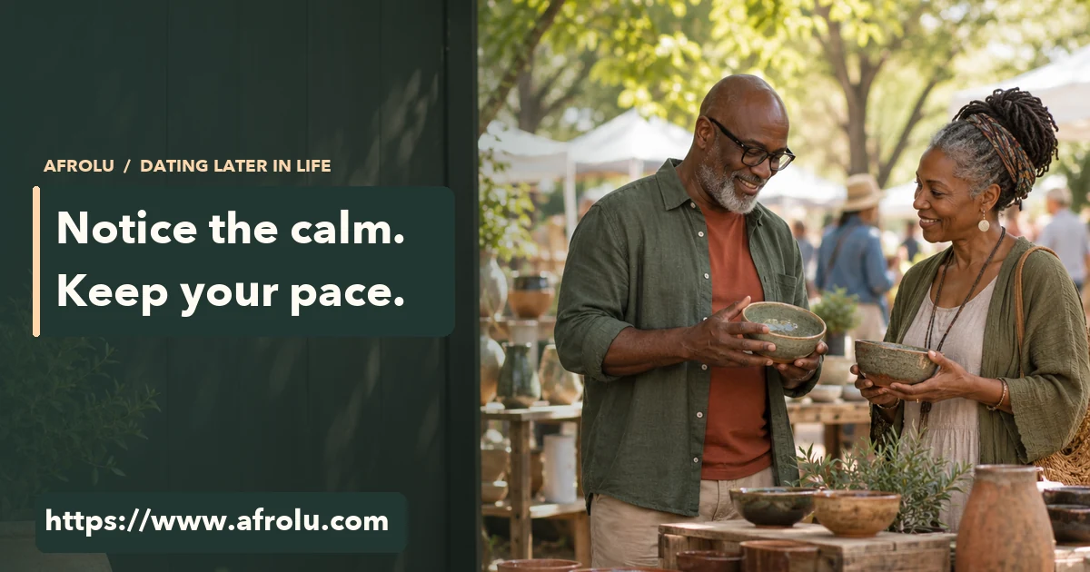 Two Black adults in their fifties smiling over handmade bowls at a community pottery fair.