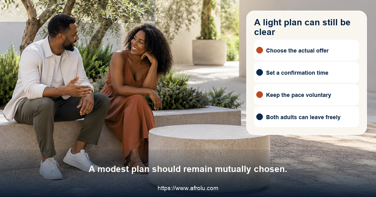 Two clearly adult Black people in a calm public garden courtyard agreeing on a short plan beside a blank analog-style token, with no school or workplace cues.