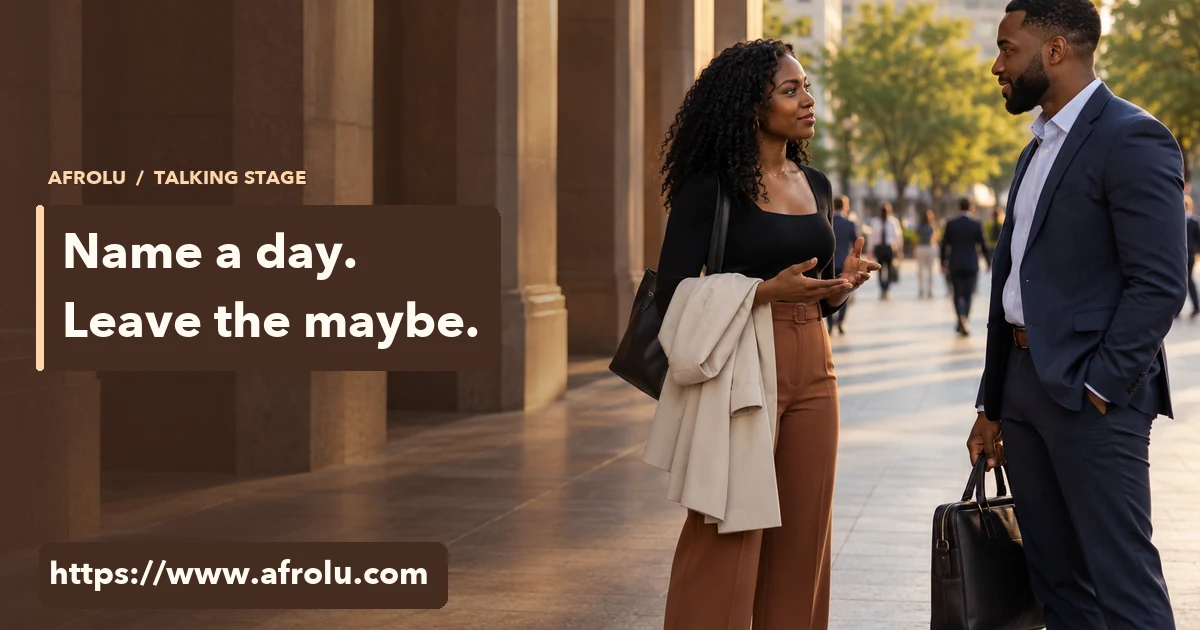 Two adults talk in a public city plaza after work, each carrying their own things.