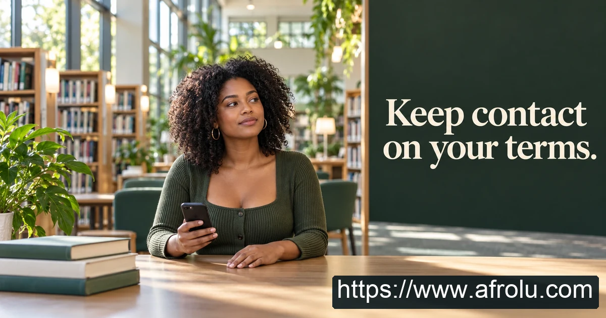 An adult sits at a library table holding a phone.
